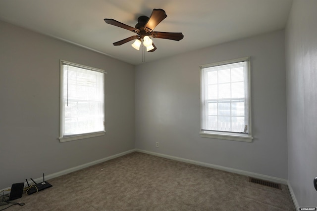 spare room with carpet, a ceiling fan, and baseboards