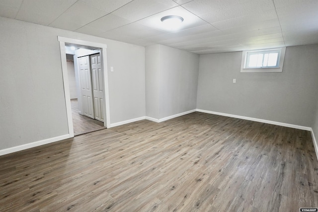 below grade area featuring wood finished floors and baseboards