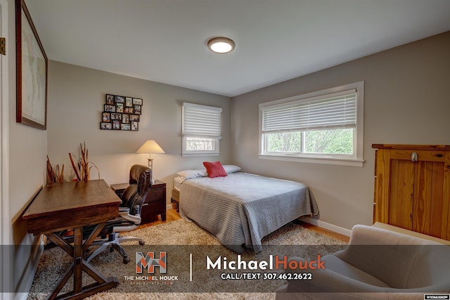 bedroom featuring wood finished floors, a desk, and baseboards