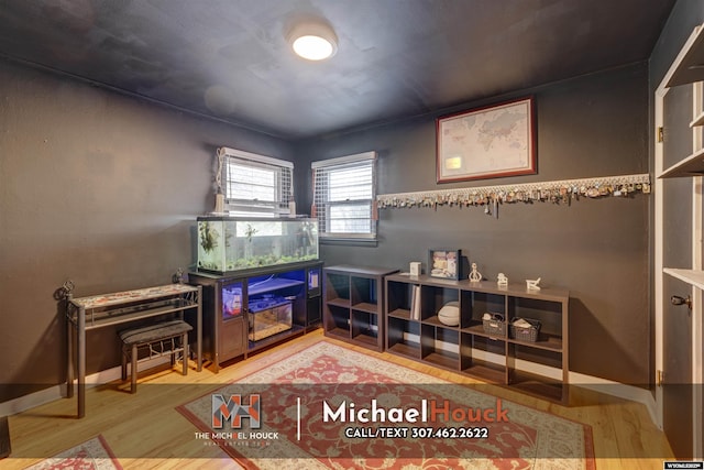 rec room featuring light wood-type flooring and baseboards