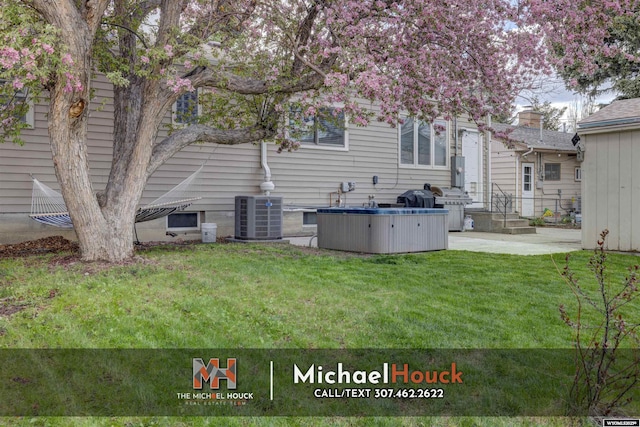 rear view of property featuring cooling unit and a yard