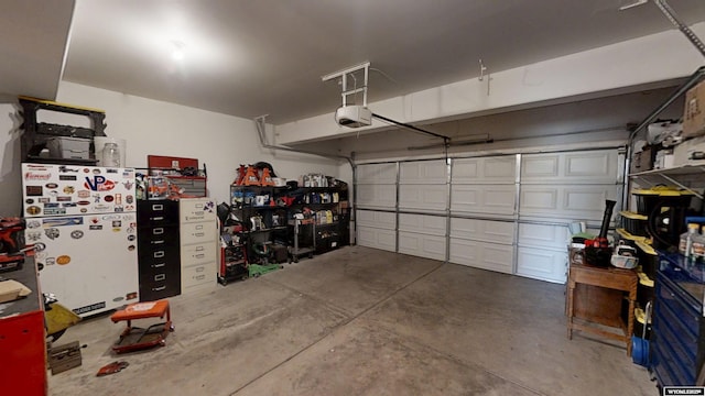 garage with freestanding refrigerator and a garage door opener
