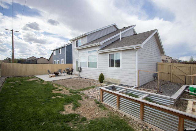 rear view of house with a patio, roof with shingles, a garden, and a gate