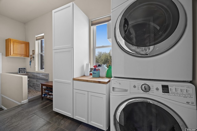 laundry room with stacked washer / dryer and cabinet space
