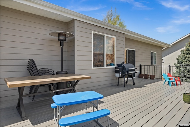wooden deck with outdoor dining area and area for grilling