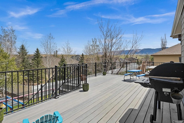wooden deck with area for grilling and a mountain view