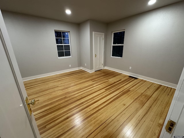 spare room with light wood-style floors, recessed lighting, and baseboards