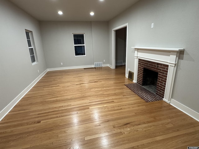unfurnished living room featuring a fireplace, wood finished floors, recessed lighting, and baseboards