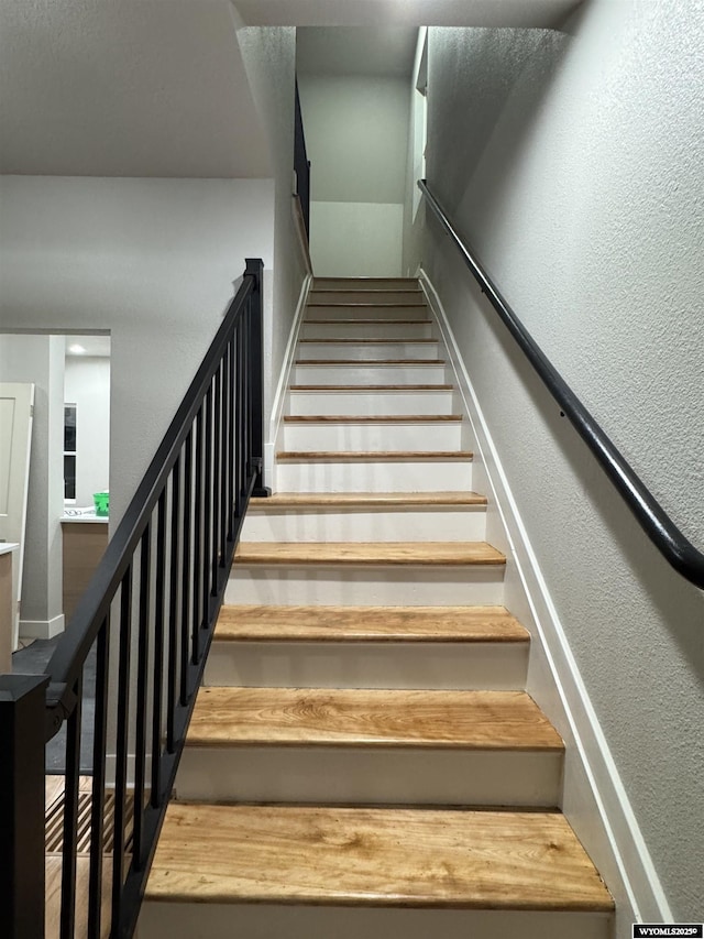 stairway featuring a textured wall