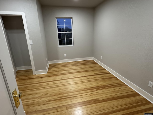 spare room with light wood-style floors and baseboards