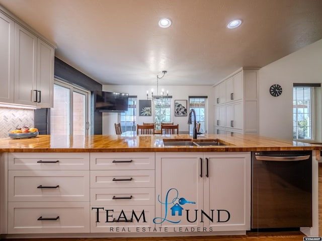 kitchen featuring dishwasher, wooden counters, a sink, a chandelier, and recessed lighting