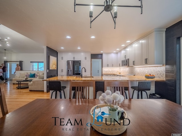 dining area with light wood finished floors and recessed lighting