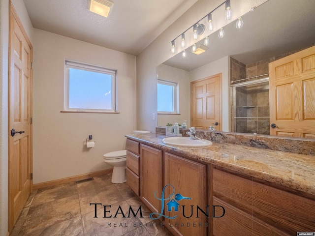 full bath with a stall shower, toilet, baseboards, and vanity