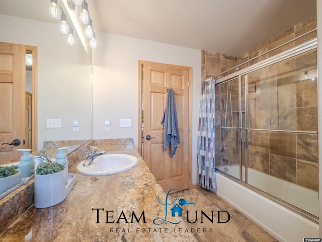 bathroom with combined bath / shower with glass door and vanity