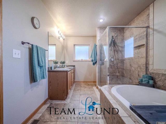 bathroom with a shower stall, vanity, a bath, baseboards, and a textured ceiling