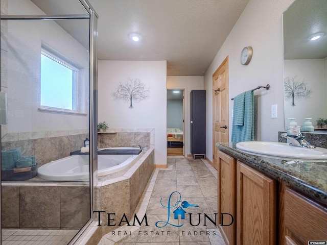 full bathroom with vanity, a garden tub, and tile patterned floors