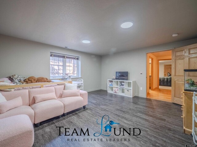 living room featuring dark wood-type flooring and baseboards