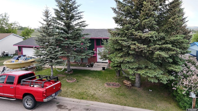 108 Cherokee Ct, Evanston, WY 82930 - obstructed view of property with roof with shingles, a front yard, a garage, and entry steps