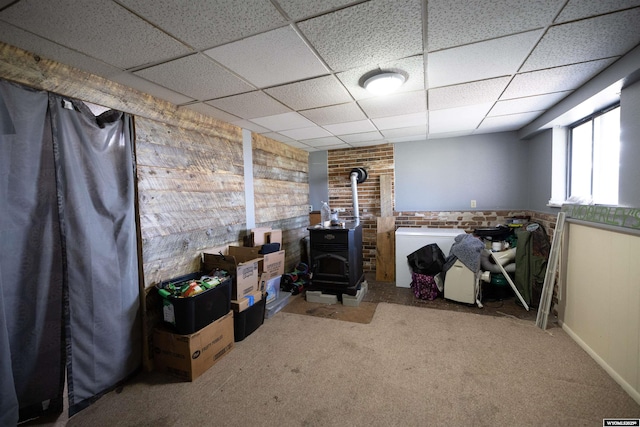 108 Cherokee Ct, Evanston, WY 82930 - basement with a wood stove, a paneled ceiling, and carpet flooring