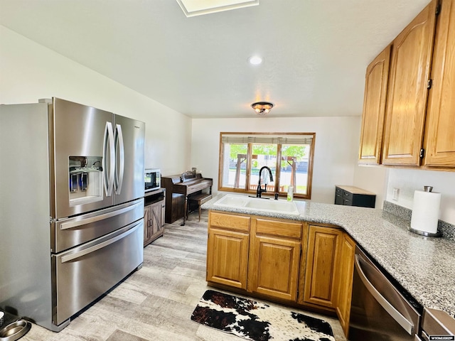 920 Laramie St, Rock Springs, WY 82901 - kitchen featuring stainless steel appliances, a sink, light wood finished floors, and light countertops
