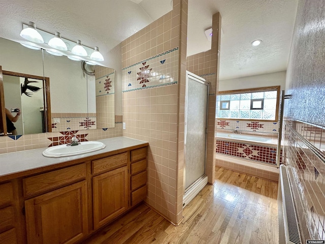 920 Laramie St, Rock Springs, WY 82901 - full bathroom featuring a textured ceiling, wood finished floors, a stall shower, a bath, and vanity