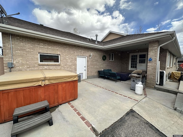 920 Laramie St, Rock Springs, WY 82901 - back of house with a hot tub, a patio, brick siding, and an outdoor living space