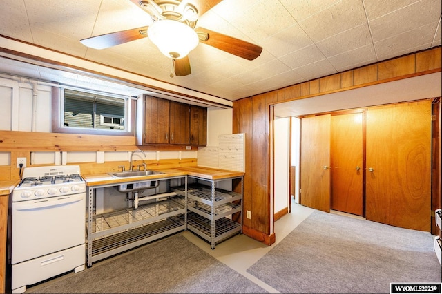 223 S Thurmond St, Sheridan, WY 82801 - kitchen featuring gas range gas stove, a sink, wooden walls, light countertops, and ceiling fan