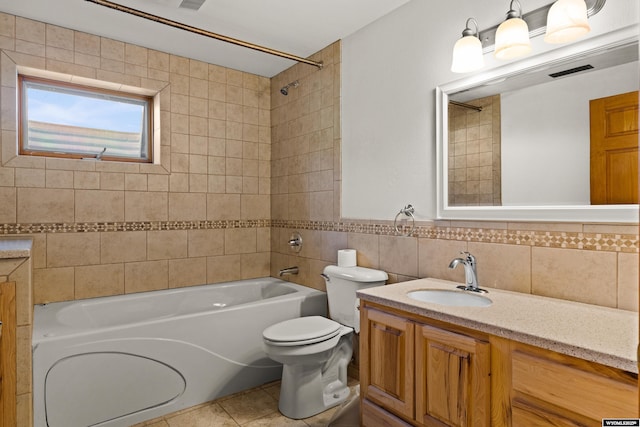 full bath featuring tile walls, toilet, shower / bath combination, vanity, and tile patterned flooring