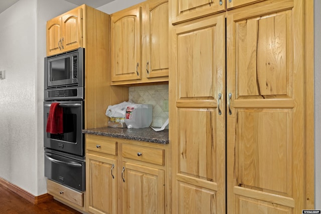 kitchen with appliances with stainless steel finishes, a warming drawer, tasteful backsplash, baseboards, and dark wood-style flooring