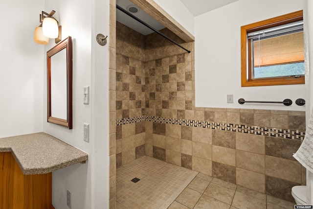 full bath with tiled shower and tile patterned floors
