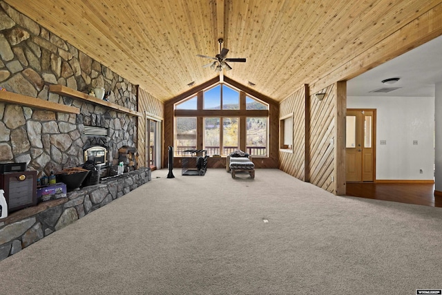 carpeted living room featuring ceiling fan, wood ceiling, a wood stove, and lofted ceiling