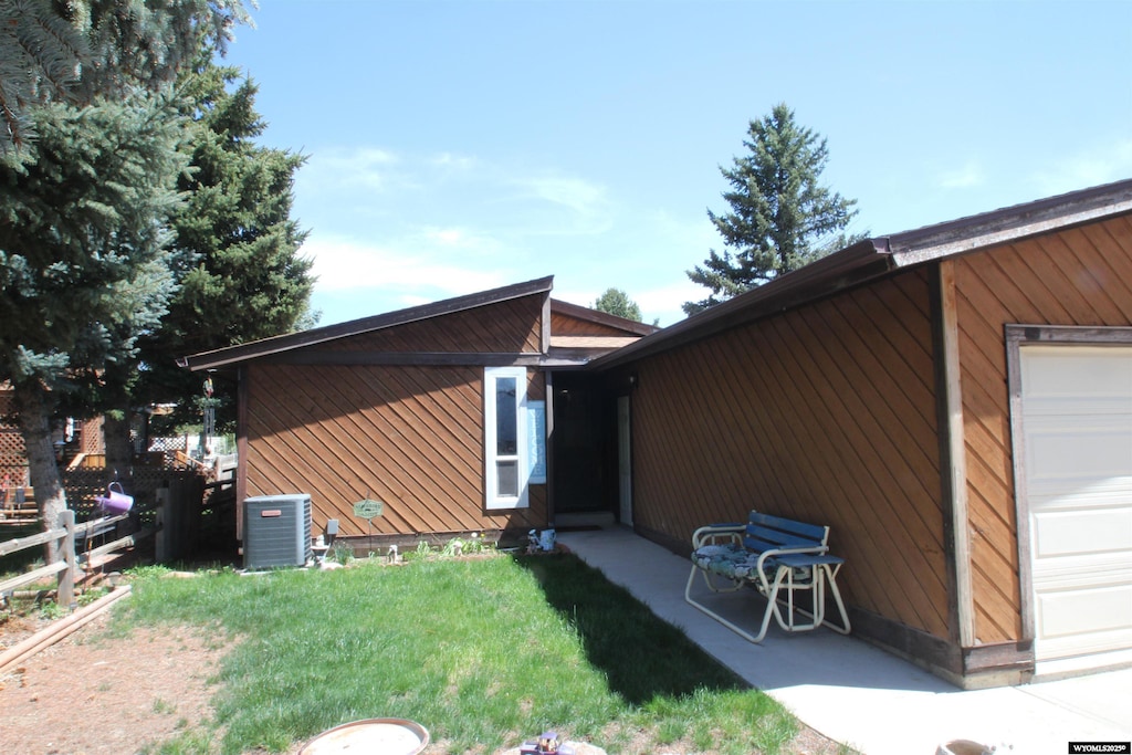 view of side of home with central AC unit and a garage