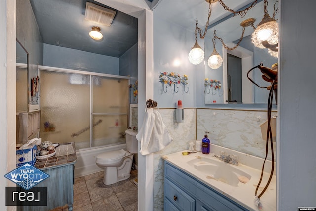 full bathroom with toilet, vanity, and bath / shower combo with glass door