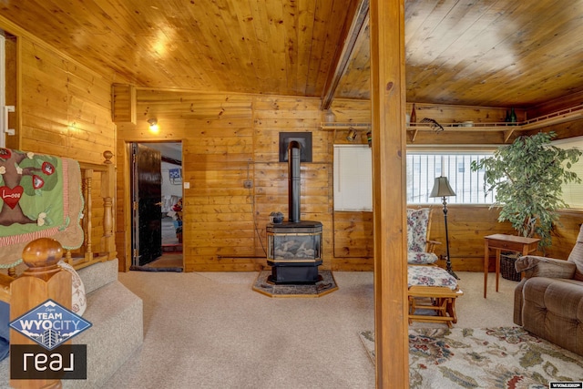 living room featuring wooden walls, carpet floors, wood ceiling, and a wood stove
