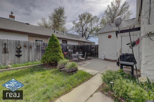 view of yard with fence and a patio