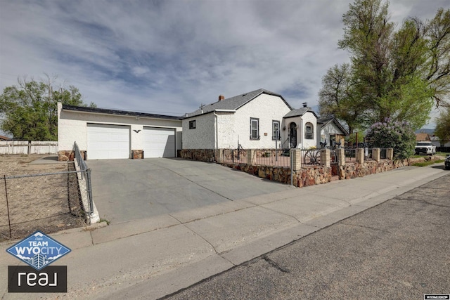 view of front of home featuring driveway, stone siding, and a garage