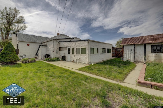 back of property featuring a patio, a gate, and stucco siding