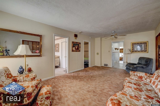 living area with a textured ceiling, carpet, ceiling fan, and baseboards