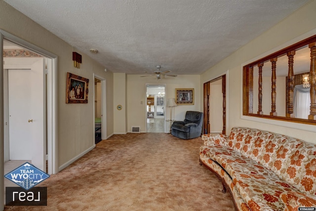 living room featuring a textured ceiling, carpet floors, and a ceiling fan