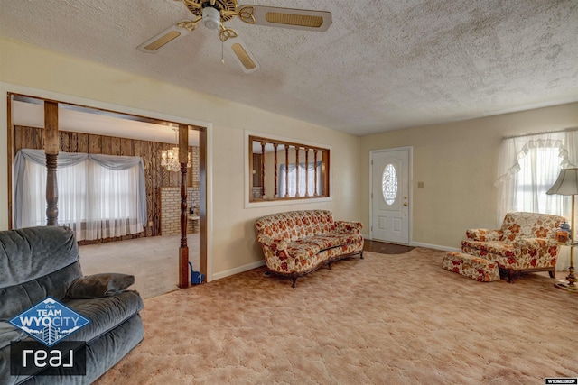 carpeted living area featuring plenty of natural light, ceiling fan, a textured ceiling, and baseboards