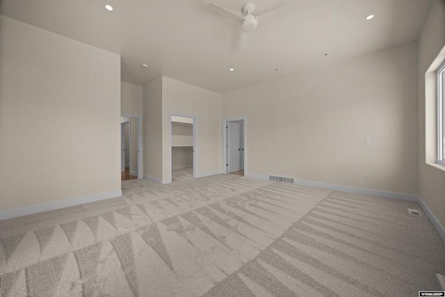 spare room featuring light colored carpet, a ceiling fan, baseboards, and recessed lighting