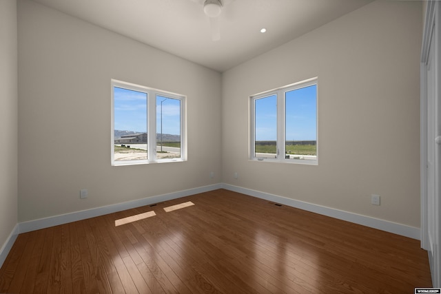 empty room with dark wood-type flooring and baseboards