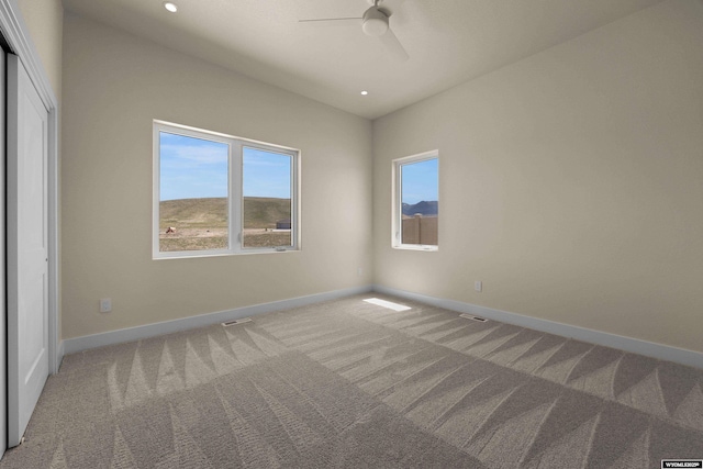 unfurnished bedroom featuring light colored carpet, baseboards, recessed lighting, ceiling fan, and a closet