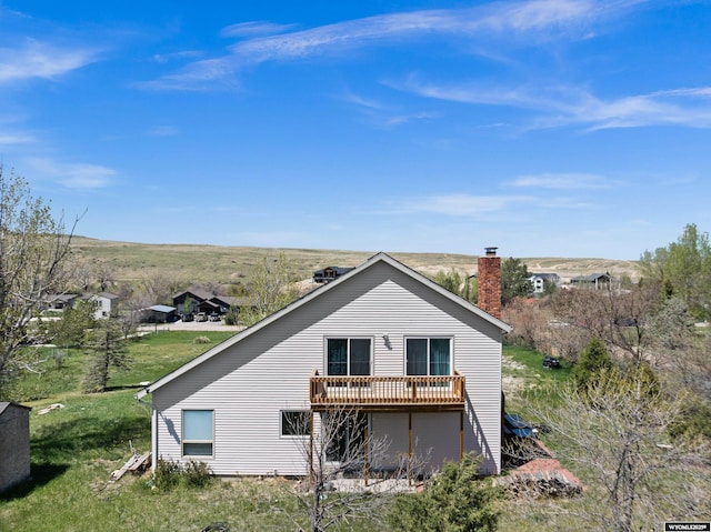 rear view of property featuring a chimney and a deck