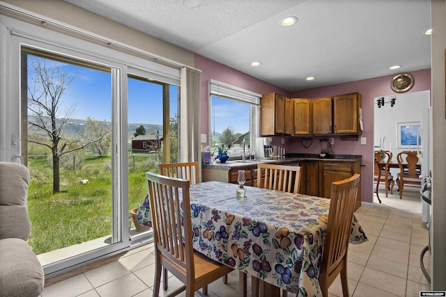 dining room featuring light tile patterned flooring, recessed lighting, and a textured ceiling