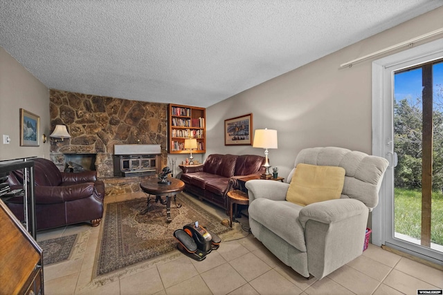 living area featuring a textured ceiling, light tile patterned floors, and a fireplace