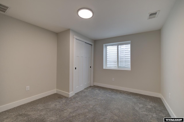 unfurnished bedroom with carpet floors, baseboards, and a closet