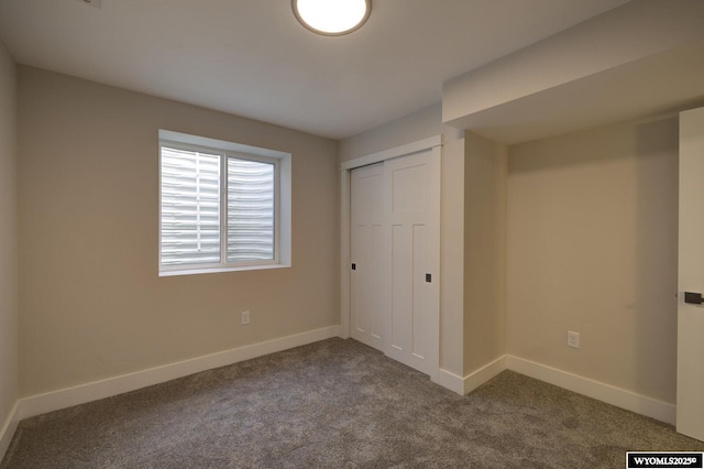 unfurnished bedroom with carpet floors, baseboards, and a closet