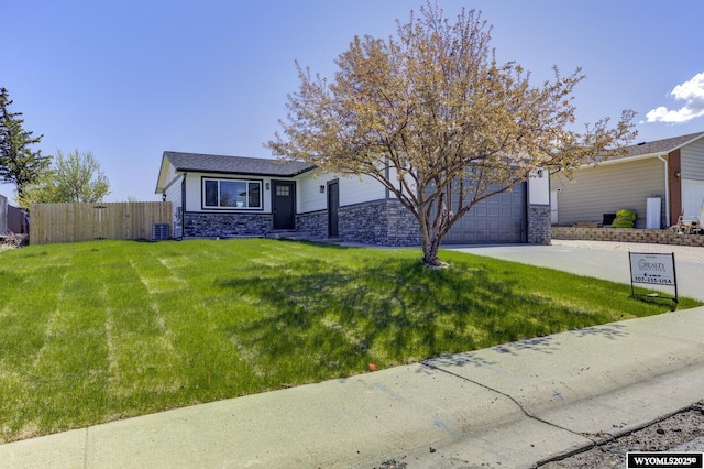 view of front of property with an attached garage, stone siding, concrete driveway, and central AC unit