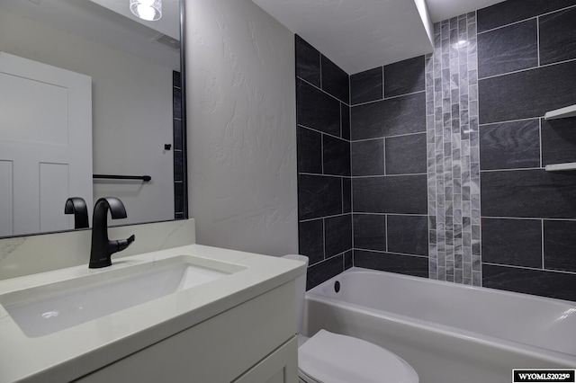 full bath featuring vanity, toilet, shower / bath combination, and a textured wall